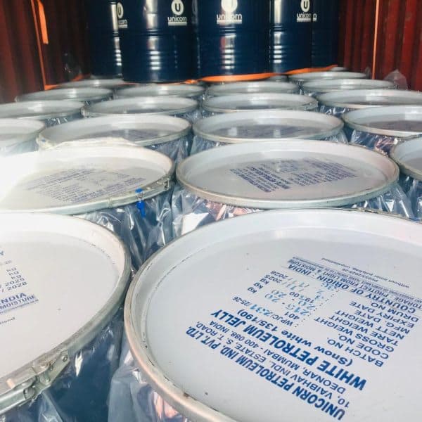 Sealed steel pails of white petroleum jelly from Unicorn Petroleum, stacked in a container.