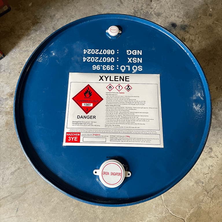 Top of a blue steel drum of xylene showing its flammable-liquid hazard label.