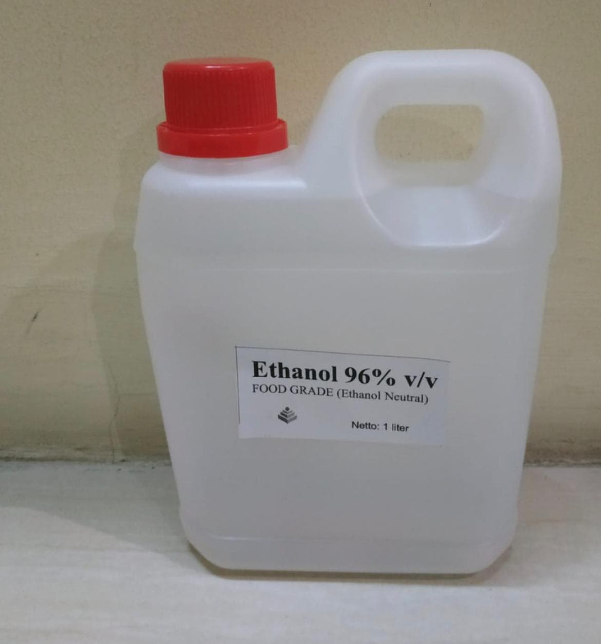 White plastic container with red cap and a label reading Ethanol 96% v/v